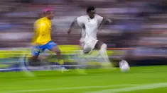 Penyerang Real Madrid Vinicius Junior (kanan) berlari dengan bola di samping bek Las Palmas Julian Araujo dalam laga pekan ke-7 La Liga 2023/2024, Kamis (28/9/2023). (AP Photo/Manu Fernandez)