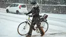 Pengendara menuntun sepedanya melewati salju tebal di Aalborg, Denmark, Selasa (27/2). Cuaca dingin di Siberia yang dijuluki "The Beast from the East" membuat suhu di sebagian Eropa turun. (AFP PHOTO/Scanpix DAN Ritzau SCANPIX/Henning Bagger/Denmark OUT)