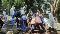 Proses pemakaman seorang warga Kota Malang diduga suspect corona Covid-19 di Kota Malang. Masyarakat diimbau tak menolak jenazah karena proses pemakaman sudah sesuai protokol (Humas Pemkot/Liputan6.com/Zainul Arifin)