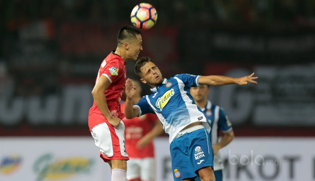 Pemain Persija Jakarta, Arthur Irawan (kiri) berduel dengan pemain RCD Espanyol pada laga persahabatan di Stadion Patriot, Bekasi, (19/7/2017). Persija kalah 0-7. (Bola.com/Nicklas Hanoatubun)