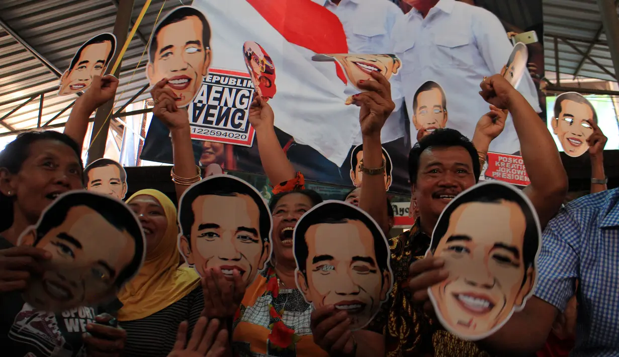 Sejumlah pedagang dan pengunjung mengenakan topeng bergambar Jokowi di Pasar Gede, Solo, (20/10/14). (ANTARA FOTO/Maulana Surya)