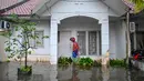 Badan Penanggulangan Bencana Daerah (BPBD) Aceh Besar mengimbau masyarakat untuk tetap waspada terhadap potensi banjir susulan, mengingat kondisi hujan masih berpotensi terjadi. Tampak dalam foto, seorang pria memeriksa rumahnya yang terendam banjir setelah hujan deras di permukiman Darul Imarah, pinggiran Banda Aceh, pada Kamis 27 November 2025. (CHAIDEER MAHYUDDIN/AFP)
