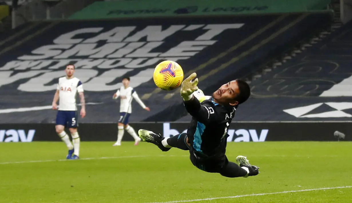 Kiper Fulham, Alphonse Areola, berusaha menghalau bola saat melawan Tottenham Hotspur pada laga Liga Inggris di London, Rabu (13/1/2021). Kedua tim bermain imbang 1-1. (Matthew Childs/Pool via AP)