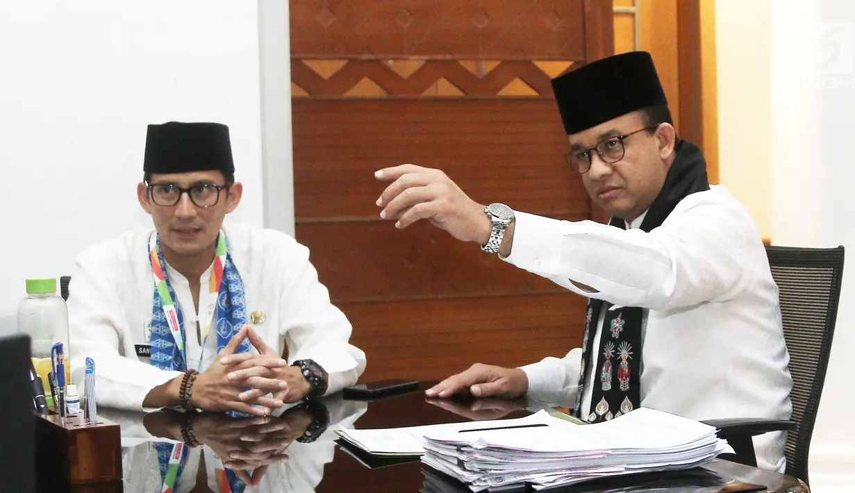 Gubernur DKI Jakarta Anies Baswedan membaca surat pengunduran diri Sandiaga Uno sebagai Wakil Gubernur di Balai Kota Jakarta, Jumat (10/8). Sandiaga mundur karena maju sebagai Cawapres pendamping Prabowo Subianto (Liputan6.com/Herman Zakharia)
