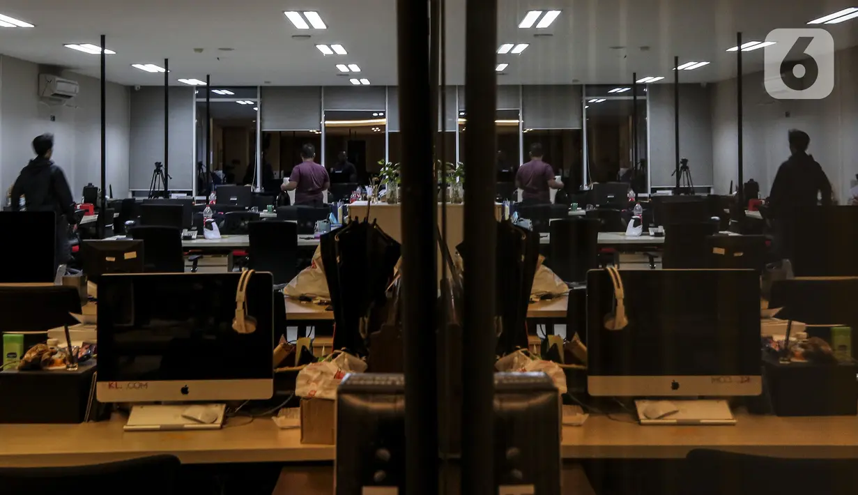 Dua karyawan bersiap meninggalkan kantor saat pemerintah memberlakukan pembatasan mobilitas warga guna menekan penyebaran COVID-19 di Jakarta, Selasa (22/6/2021). Pembatasan dilakukan pukul 21.00-04.00 WIB di 10 titik Ibu Kota. (Liputan6.com/Johan Tallo)