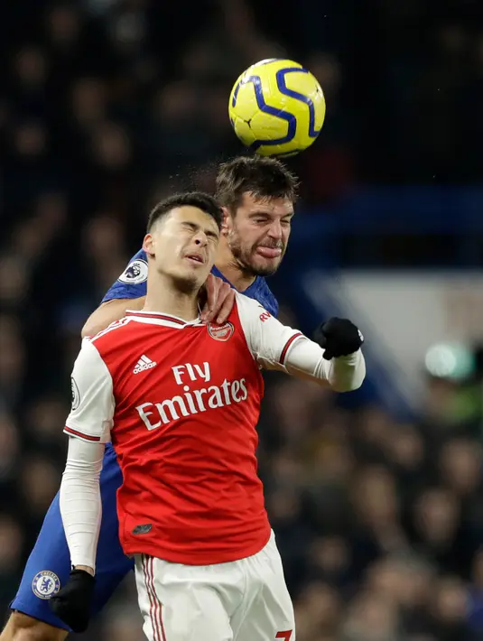 Penyerang Arsenal, Gabriel Martinelli melompat saat berebut bola dengan kapten Chelsea, Cesar Azpilicueta pada lanjutan pertandingan Liga Inggris di Stamford Bridge, Selasa (21/1/2020). Chelsea gagal memetik hasil maksimal usai ditahan Arsenal dengan skor 2-2. (AP Photo/Matt Dunham)