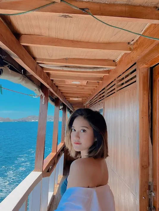 Dengan mengenakan busana putih dan topi, Salshabilla Adriani pun nampak memesona. Apalagi kini ia juga punya penampilan baru. Yaitu dengan rambut pendeknya yang sebelumnya selalu panjang. Pemandangan yang indah pun terlihat indah disaksikan dari atas kapal. (Liputan6.com/IG/@salshabillaadr)