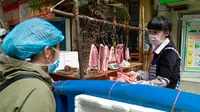 Seorang wanita membeli daging di Wuhan, ibu kota Provinsi Hubei, China tengah, (16/4/2020). Seiring meredanya epidemi COVID-19, kehidupan berangsur kembali normal di Wuhan. (Xinhua/Shen Bohan)