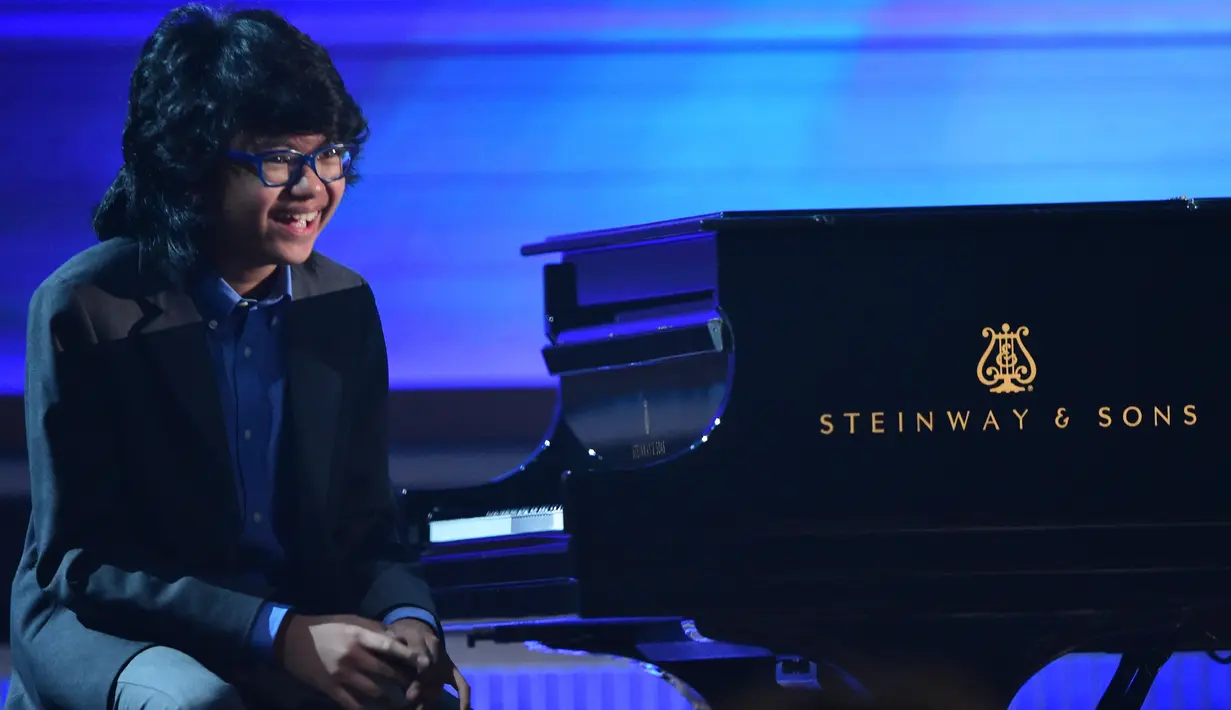 Senyum pianis muda Indonesia, Joey Alexander saat tampil di ajang Grammy Awards 2016 di Los Angeles, Senin (15/2). Sorotan industri musik internasional semakin besar terhadap Joey setelah tampil dalam malam puncak penghargaan Grammy (AFP PHOTO/Robyn BECK)