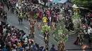 Warga menyaksikan peserta menampilkan kreasi kostum dalam Jember Fashion Carnaval (JFC) di Jember, Provinsi Jawa Timur pada Minggu (4/8/2019). Kegiatan ini mengangkat tema 'tribal grandeur', dengan menghadirkan keagungan 8 suku di dunia. (Photo by JUNI KRISWANTO / AFP)