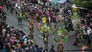 Warga menyaksikan peserta menampilkan kreasi kostum dalam Jember Fashion Carnaval (JFC) di Jember, Provinsi Jawa Timur pada Minggu (4/8/2019). Kegiatan ini mengangkat tema 'tribal grandeur', dengan menghadirkan keagungan 8 suku di dunia. (Photo by JUNI KRISWANTO / AFP)