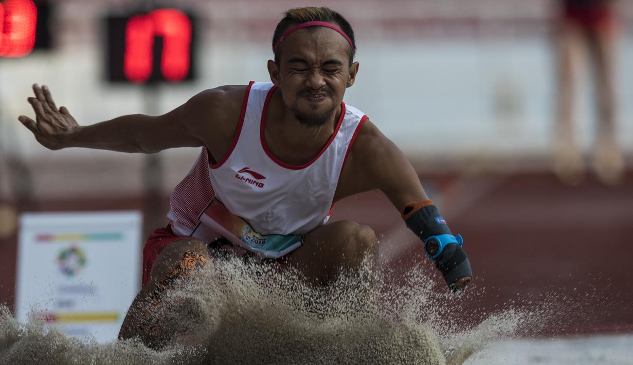Atlet lompat jauh Indonesia, Settiyo Budi Hartanto, mendarat saat tampil pada cabang atletik nomor lompat jauh  T 45/46/47 Asian Para Games di SUGBK, Jakarta, Senin (8/10/2018). (Bola.com/Vitalis Yogi Trisna)