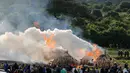 Warga melihat proses pembakaran gading gajah di Nairobi National Park, Kenya (30/4). Petugas memusnahkan sekitar 105 ton gading hasil penyitaan dari penyelundup dan pemburu. (Reuters/Thomas Mukoya)