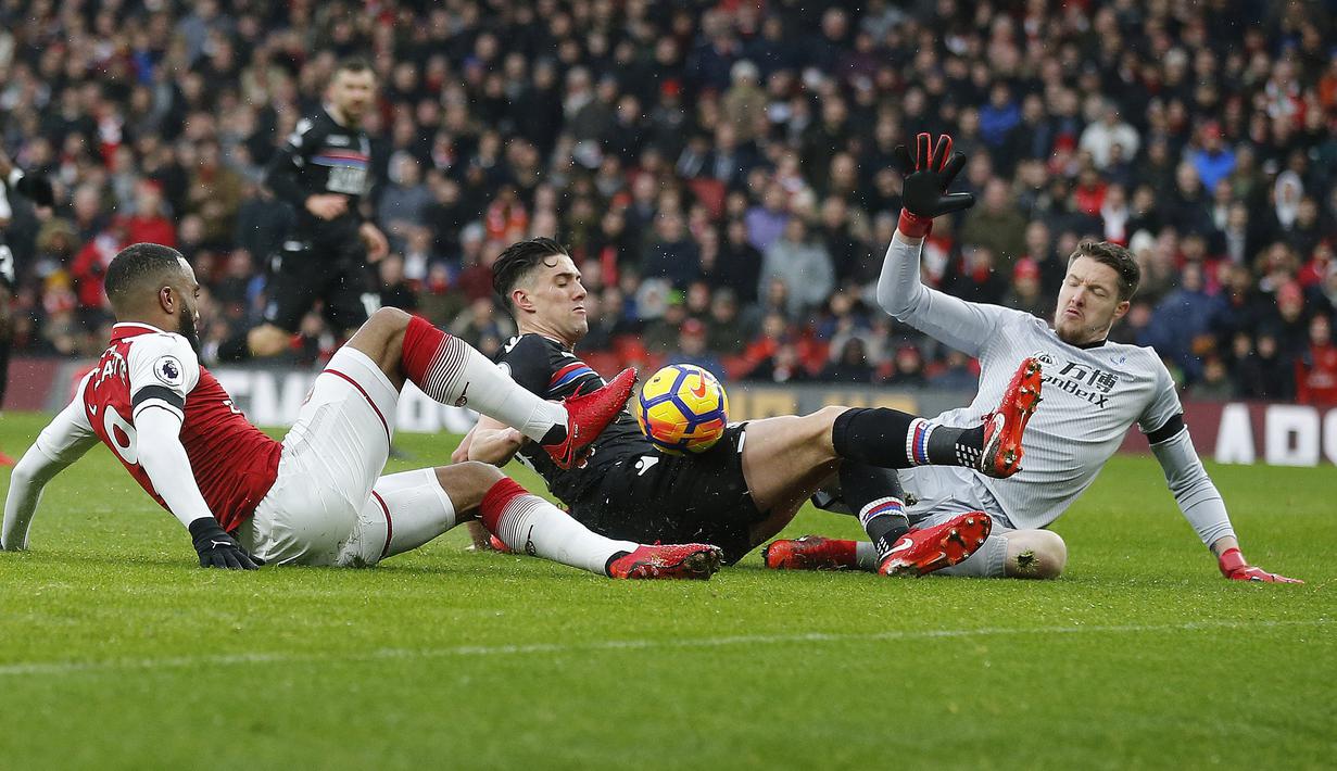 Pemain Arsenal, Alexandre Lacazette (kiri) berebut bola dengan pemain Crystal Palace, Timothy Fosu-Mensah dan Kiper Wayne Hennessey pada lanjutan Premier League di Emirates stadium, London, (20/1/2018). Arsenal menang 4-1. (AP/Frank Augstein)