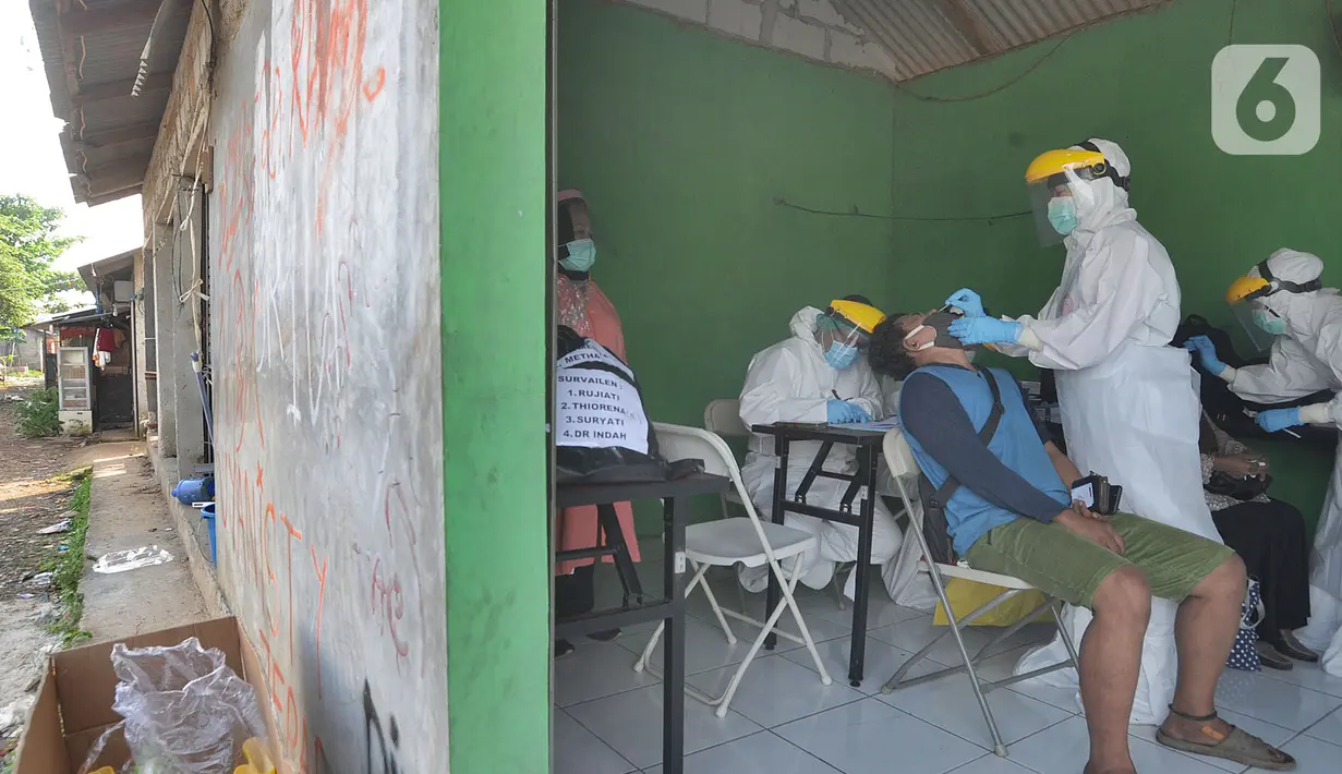 Petugas medis dari Pemkot Jakarta Selatan melakukan tes swab Covid-19 para pedagang  di Pasar Sayur Cipulir, Jakarta Selatan, Kamis (25/6/2020). Kegiatan yang dilakukan kepada puluhan pedagang dan warga seputar pasar ini dalam rangka memutus mata rantai penyebaran Covid-19. (merdeka.com/Arie Basuki)