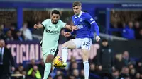 Penyerang Chelsea, Armando Broja, berduel dengan gelandang Everton, Alex Matos, pada laga Premier League 2023/2024 yang digelar di Goodison Park, Minggu (10/12/2023) malam WIB. (AFP/Peter Powell)