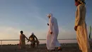 Dua anak laki-laki bersiap melepaskan anjing Arab Saluki saat balapan di Festival Unta Mazayin Dhafra di dekat kota Madinat Zayed, Abu Dhabi (26/12). Lomba balap anjing Saluki ini memeriahkan festival unta tersebut. (AFP Photo/Karim Sahib)