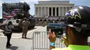 Pekerja mengambil gambar saat kendaraan pengangkut lapis baja Bradley dipindahkan di depan Lincoln Memorial, Washington, Rabu (3/7/2019). Donald Trump akan memamerkan tank-tank tempur sebagai bagian dari perayaan Hari Kemerdekaan AS yang dikenal sebagai Fourth of July. (Mark Wilson/Getty Images/AFP)