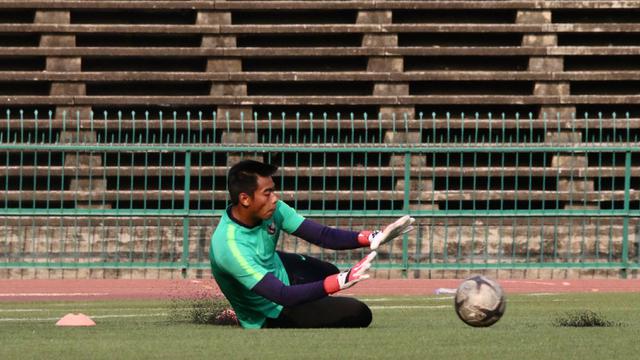 Kiper Timnas Indonesia U-22, Satria Tama, berusaha menangkap bola saat latihan. (Bola.com/Zulfirdaus Harahap)