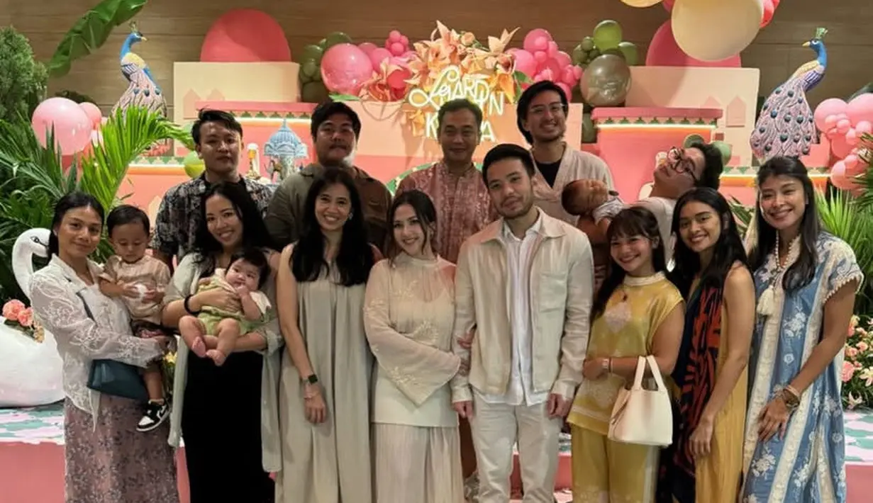 Amel Carla mengenakan setelan kuning dari atasan sleeveless dipadukan long pants. Ia membawa handbag putih. [@amelcarla]