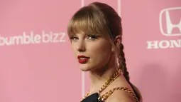 Taylor Swift berpose saat tiba menghadiri Billboard Women In Music 2019 yang digelar oleh YouTube Music di Los Angeles, California (12/12/2019). Taylor Swift cantik memesona dengan jumpsuit biru. (AP Photo/Chris Pizzello)