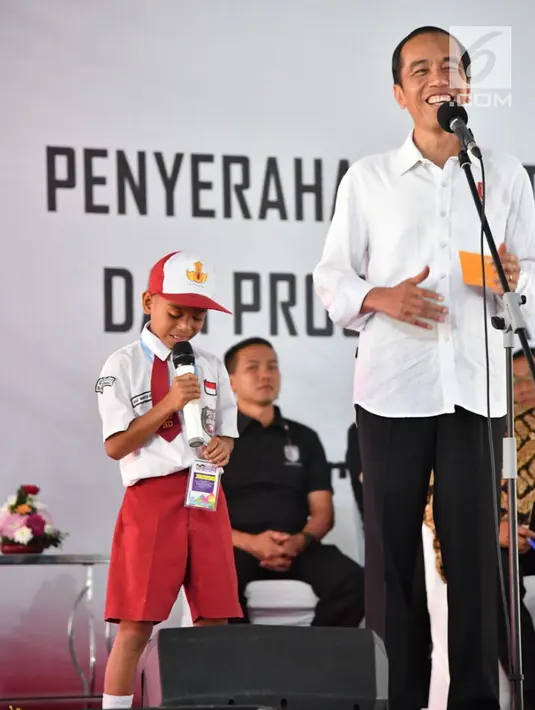 Presiden Jokowi memberikan pertanyaan kepada seorang siswa saat penyerahan KIP dan PKH di SMA Negeri 1 Palembang, Sumatra Selatan (22/1). Presiden Jokowi mengingatkan agar bantuan tersebut dipergunakan sebagaimana mestinya.(Liputan6.com/Pool/Biro Setpres)