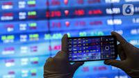 Karyawan mengambil gambar layar Indeks Harga Saham Gabungan (IHSG) di Bursa Efek Indonesia, Jakarta, Jumat (22/1/2021). Sebanyak 111 saham menguat, 372 tertekan, dan 124 lainnya flat. (Liputan6.com/Johan Tallo)