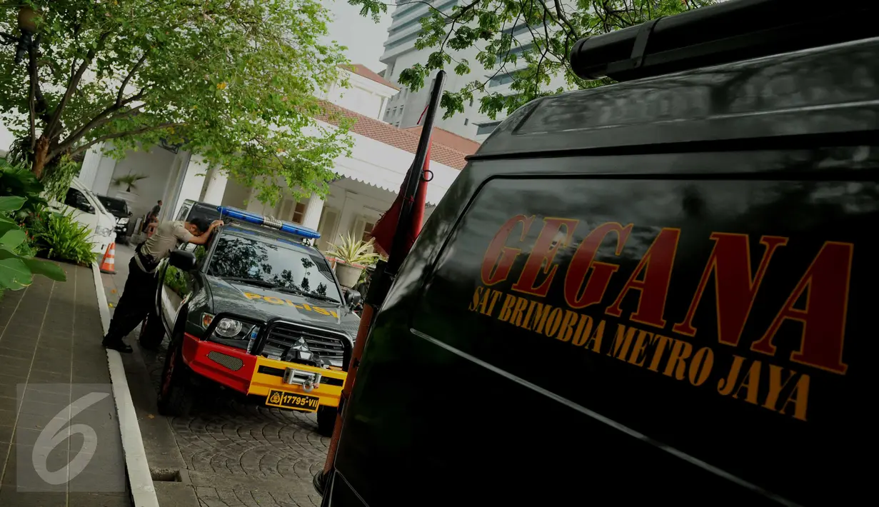 Seorang anggota polisi bersandar di samping mobil Tim Gegana yang dikerahkan ke Balai Kota DKI Jakarta, Rabu (20/7). Pengamanan kantor Gubernur Ahok diperketat setelah menerima ancaman teror bom dari orang tak dikenal. (Liputan6.com/Gempur M Surya)