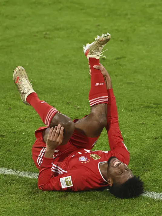 Pemain Bayern Munchen Kingsley Coman meringis karena cedera saat melawan Bayer Leverkusen pada pertandingan Bundesliga di Stadion Allianz Arena, Munchen, Jerman, Selasa (20/4/2021). Bayern Munchen menang 2-0. (Christof Stache, Pool via AP)