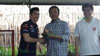 Marc Marquez memberikan cinderamata berupa replika motor balap kepada  Menpora, Imam Nahrowi didampingi CEO AHM, Yohanes Loman (kanan) di Lapangan Futsal Kuningan Village, Jakarta, Sabtu (13/2/2016). (Bola.com/Nicklas Hanoatubun)