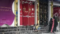 Perempuan berjalan melewati salon kecantikan di daerah Shahr-e Naw di Kabul, Afghanistan pada Selasa (4/7/2023). (Photo by Wakil KOHSAR / AFP)