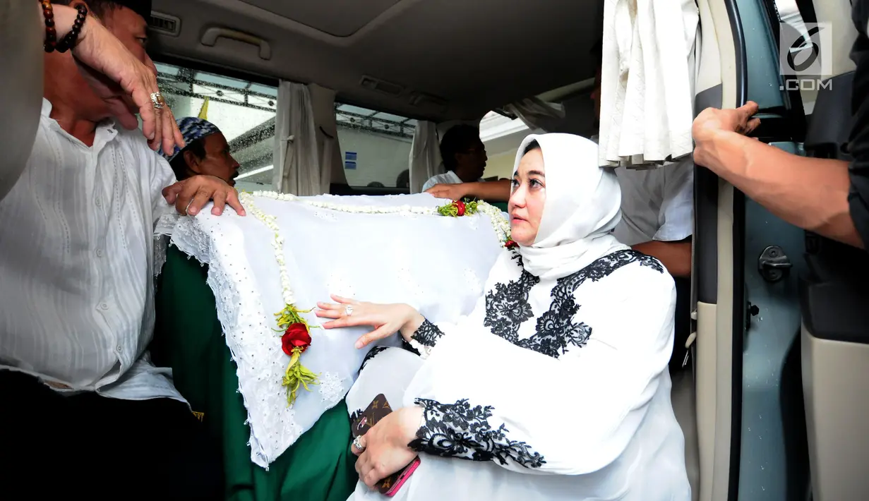 Istri alm RMH Heroe Siswanto NS atau dikenal Sys NS, Shanty Widhiyanti di sisi jenazah saat dibawa dari rumah duka, Jakarta, Selasa (23/1). Sys NS wafat diusia 61 tahun akibat serangan jantung. (Liputan6.com/Helmi Fithriansyah)