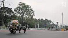 Delman saat berjalan di antara kendaraan di kawasan Monas, Jakarta, Selasa (3/7). Pemprov DKI Jakarta melarang delman beroperasi di Jakarta Pusat selama perhelatan Asian Games 2018. (Merdeka.com/Iqbal Nugroho)