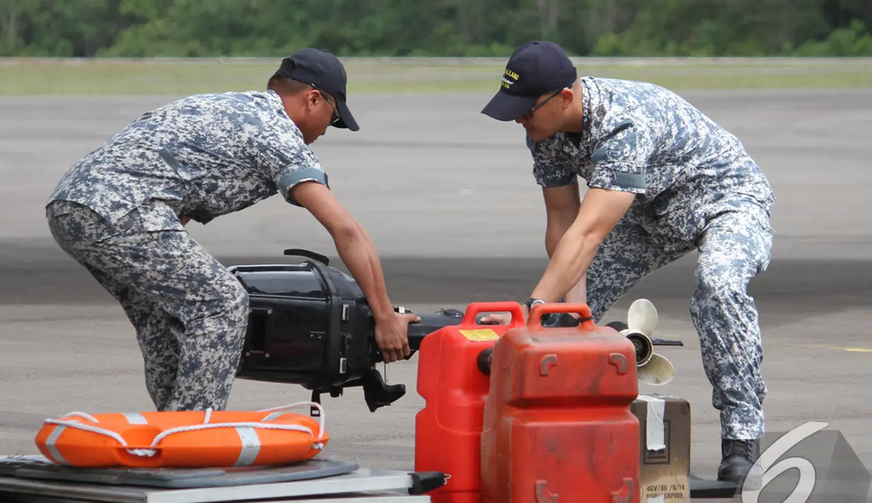 Dua orang personil militer Singapura meletakkan barang bantuan dengan hati-hati, Pangkalan Bun, Kalteng, Kamis (1/1/2015). (Liputan6.com/Herman Zakharia)