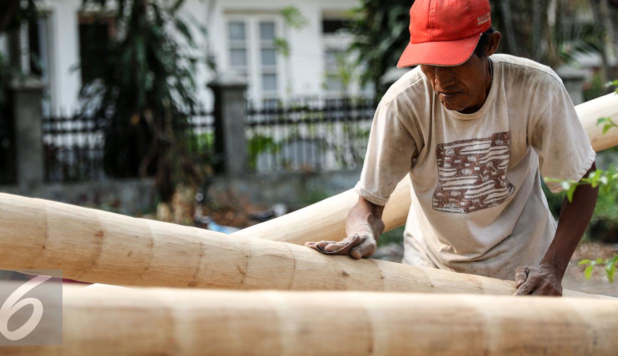 Seorang pengrajin menghaluskan batang Pohon Pinang di kawasan Manggarai, Jakarta, Senin (10/8/2015). Jelang HUT Kemerdekaan RI  permintaan Pohon Pinang meningkat dengan nilai jual berkisar Rp 900 ribu- Rp 1 juta. (Liputan6.com/Yoppy Renato)