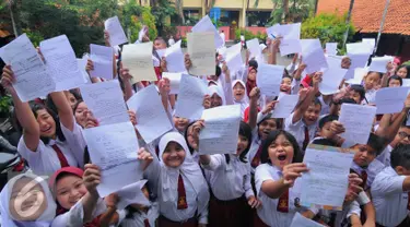 Siswa-siswi menunjukan surat untuk Presiden RI. Joko Widodo di SDN Sukasari 4 Kota Tangerang, Selasa, (29/16). Isi Surat tersebut meminta kepada Jokowi agar prihatin dengan keberadaan generasi muda Indonesia. (Liputan6.com/Faisal R Syam)