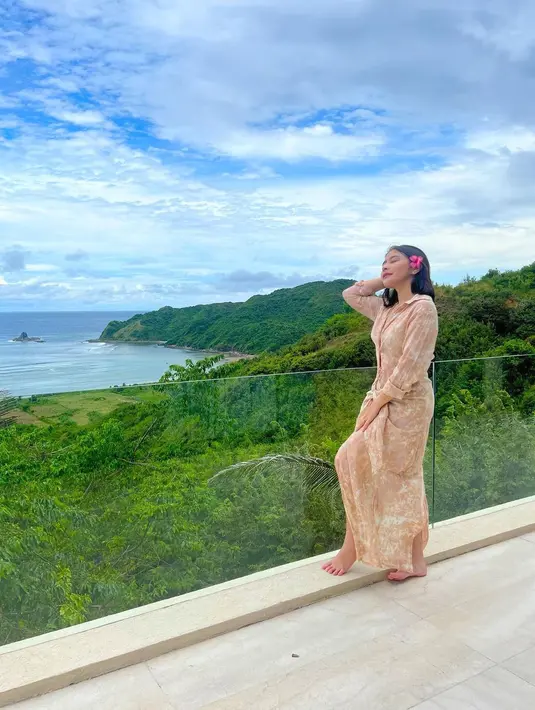 Kembali menikmati pemandangan alam yang indah, Prilly berpose lebih feminin nan cantik. Ia tampak mengenakan long dress bermotif tie-dye bernuansa cokelat-oranye muda yang lembut. Prilly menambahkan bunga yang diselipkan di salah satu telinganya. Foto: Instagram.