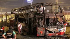 Petugas kepolisian berdiri dekat kerangka sebuah bus bertingkat yang hangus terbakar di terminal bus antarprovinsi, kota Lima, Peru, Minggu (31/3) malam. Sedikitnya 20 orang tewas dan belasan lainnya terluka dalam peristiwa nahas tersebut. (Photo by Luka GONZALES / AFP)