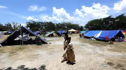 Anak-anak pengungsi berjalan di kamp pengungsian di Lapangan Masjid Agung Daru Salam, Palu, Jumat (5/10). Para pengungsi menggelar salat jumat pertama pascagempa bumi dan tsunami. (Liputan6.com/Fery Pradolo)