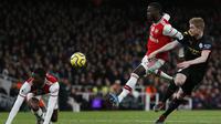Gelandang Arsenal, Nicolas Pepe, berebut bola dengan gelandang Manchester City, Kevin De Bruyne, pada laga Premier League di Stadion Emirates, London, Minggu (15/12). Arsenal kalah 0-3 dari City. (AFP/Ian Kington)