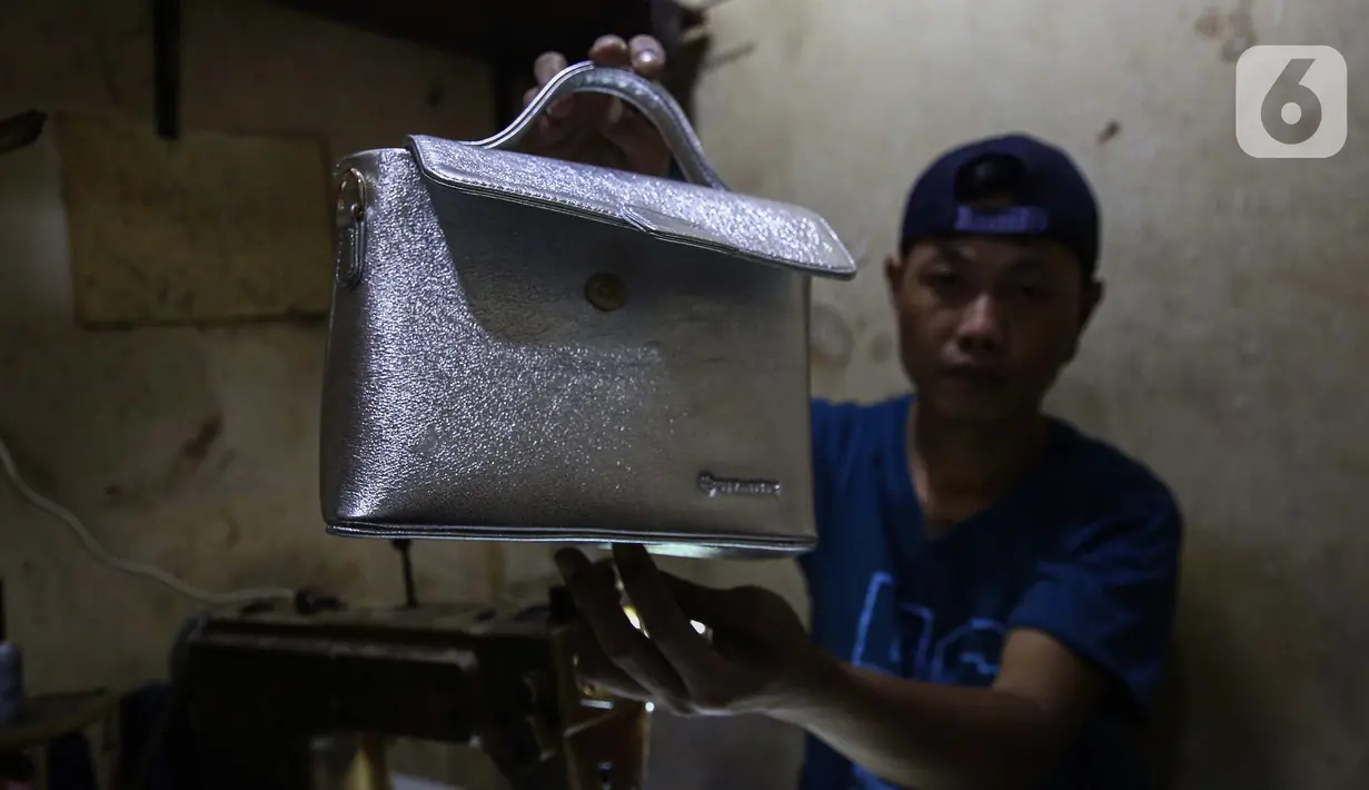 Perajin menyelesaikan pembuatan tas di ruang kerja usaha mikro, kecil, dan menengah (UMKM) pembuatan tas kulit Biyantie di kawasan Kalibata, Jakarta Selatan, Sabtu (9/11/2024). (Liputan6.com/Angga Yuniar)