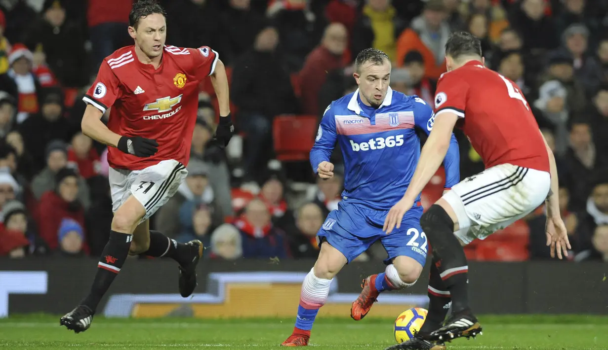 Gelandang Stoke City, Xherdan Shaqiri, berusaha melewati bek Manchester United, Phil Jones, pada laga Premier League di Old Trafford, Senin (15/1/2018). Manchester United menang 3-0 atas Stoke City. (AP/Rui Vieira)