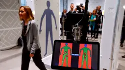 Penumpang melewati Mesin detektor full body terbaru di Bandara Cologne-Bonn Konrad Adenaue, Jerman (15/11). Mesin ini akan secara otomatis mendeteksi benda-benda yang berpotensi bahaya. (REUTERS/Wolfgang Rattay)