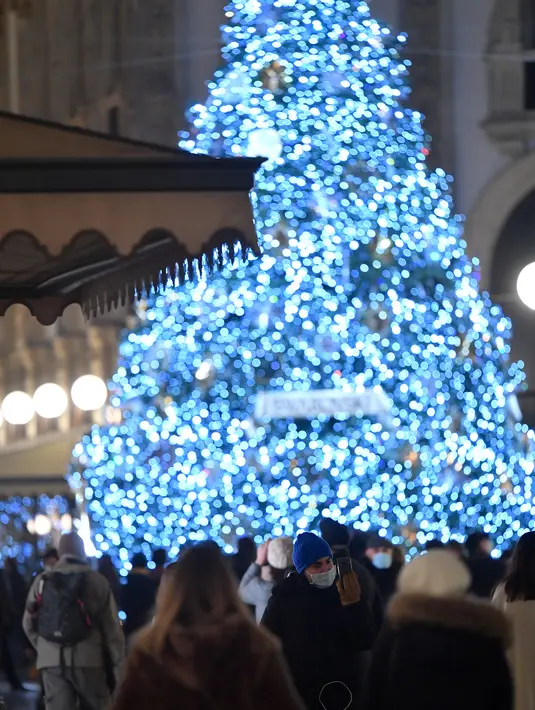 Orang-orang berjalan melewati pohon Natal di Galleria Vittorio Emanuele II di Milan, Italia, pada 7 Desember 2020. Italia mencatat 13.720 infeksi baru Covid-19 pada Senin (7/12) dan merupakan penambahan harian terendah sejak 20 Oktober lalu, yang mencapai 10.874 infeksi baru (Xinhua/Daniele Mascolo)