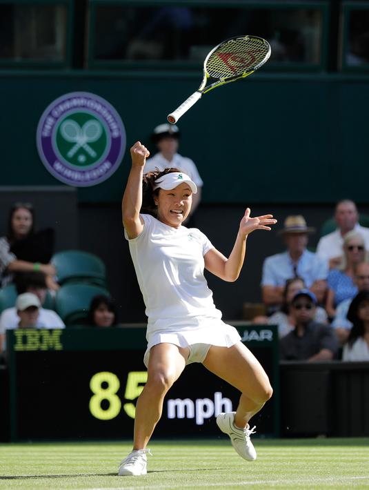 Ekspresi petenis Jepang Kurumi Nara saat raketnya terlepas dari tangan mengembalikan bola pukulan Petenis Rumania Simona Halep saat bertanding pada hari kedua tunggal putri Kejuaraan Tenis Wimbledon di London, (3/7). (AP Photo / Ben Curtis)