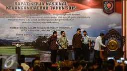 Wapres Jusuf Kalla (kanan) memukul gong sebagai tanda dibukanya Rapat Kerja Nasional Keuangan Daerah Tahun 2015 di Jakarta, Kamis (2/7/2015). Menurut JK, krisis Yunani bisa dijadikan pelajaran agar tak terjadi di Indonesia. (Liputan6.com/Faizal Fanani)