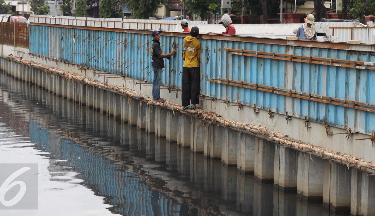 Para pekerja menyelesaikan pembangunan turap di sepanjang Kali Grogol, Jakarta, Senin (21/11). Pembangunan turap dilakukan untuk mencegah meluapnya air kali saat hujan dan ditargetkan selesai 20 Desember 2016. (Liputan6.com/Gempur M Surya)