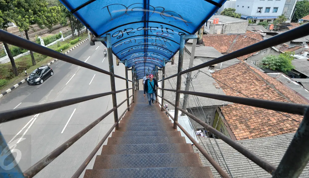 Warga melintas di JPO Jalan Raya Lenteng Agung, Jakarta Selatan, Kamis (29/12). Karat dan lubang ditemukan di jembatan penghubung atara Jalan Raya Lenteng Agung Timur dan Jalan Raya Lenteng Agung Barat itu. (Liputan6.com/Yoppy Renato)