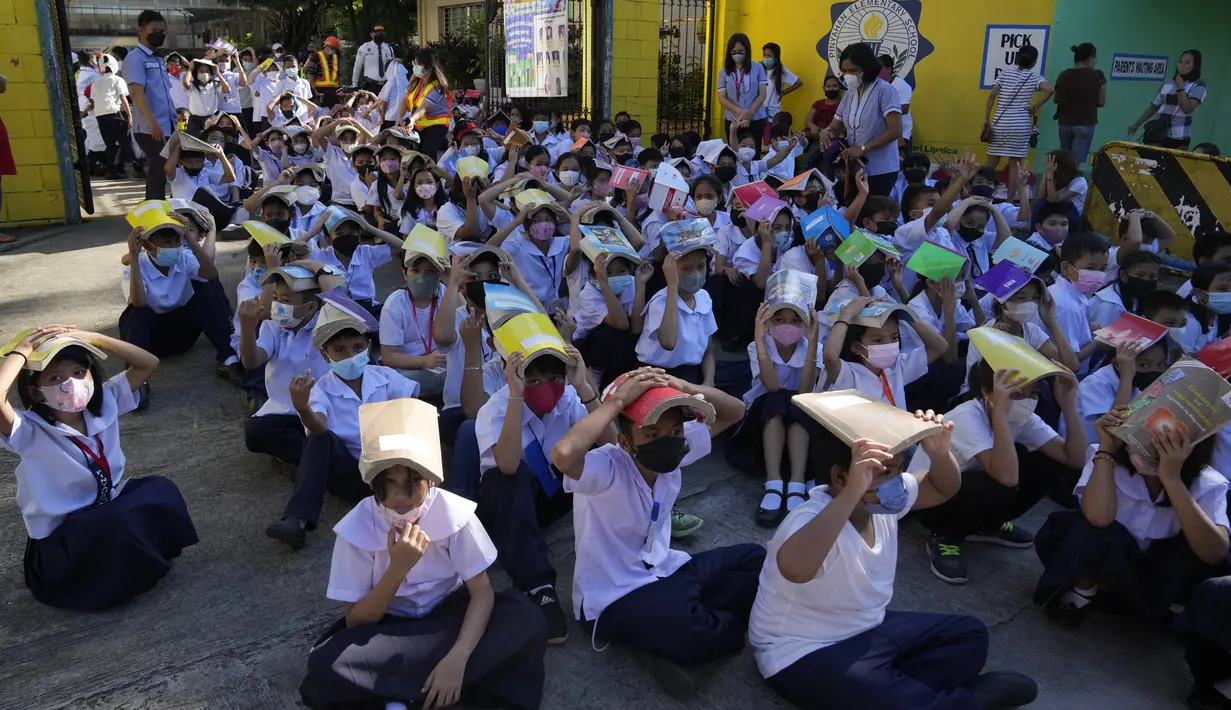 <p>Siswa menempatkan buku di kepala mereka untuk perlindungan selama latihan gempa di sebuah sekolah dasar di Metro Manila, Filipina, Kamis (8/9/2022). Filipina melakukan latihan gempa nasional kuartal ketiga sebagai bagian dari upaya untuk membuat publik mengetahui protokol dan tanggapan selama bencana. (AP Photo/Aaron Favila)</p>