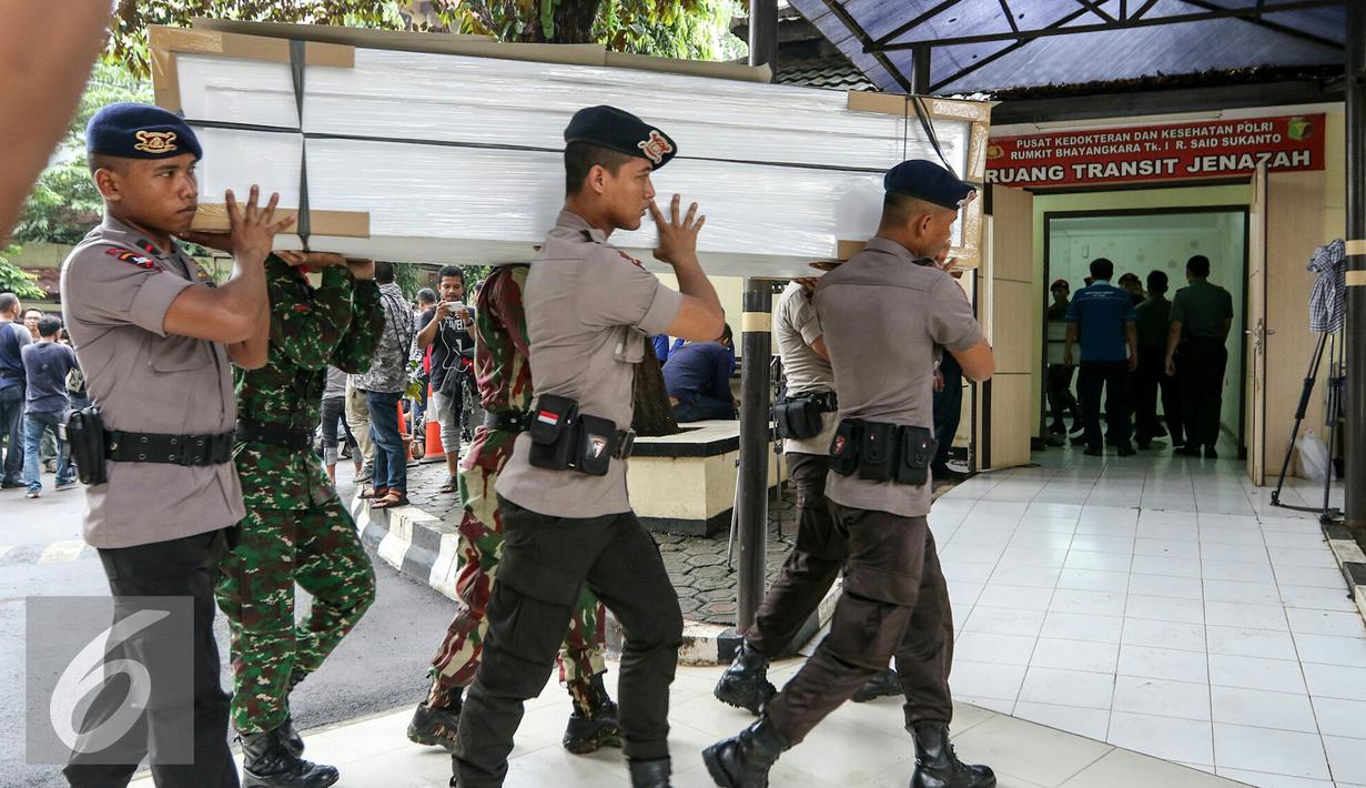 Petugas mengangkat peti ke ruang transit jenazah yang dipersiapkan untuk korban helikopter TNI yang jatuh di RS Polri, Jakarta, Senin (21/3). Seluruh jenazah dibawa ke Rumah Sakit Polri Kramat Jati. (Liputan6.com/Yoppy Renato)